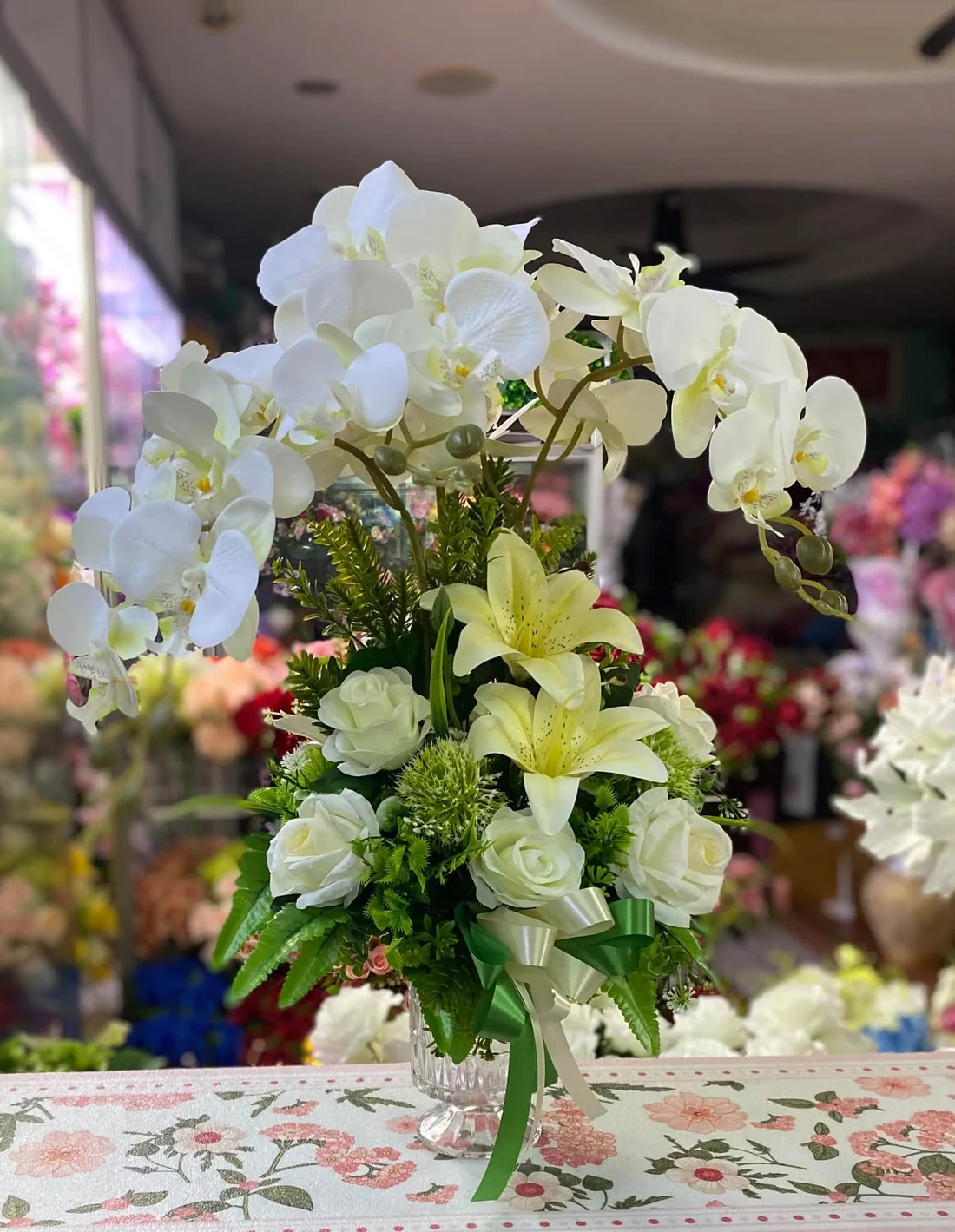 ผลงานจริง J&K Florist: กล้วยไม้ประดิษฐ์สีขาวจัดในแจกันแก้ว